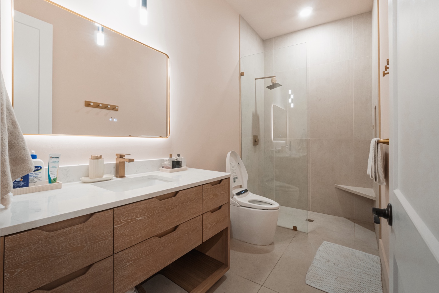 Bright bathroom with floating wood vanity and glass shower
