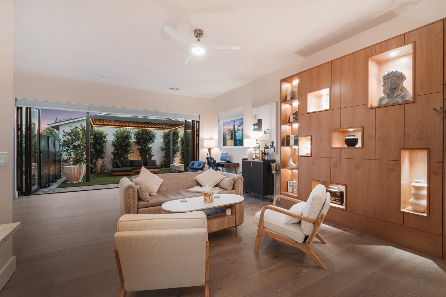 Open-plan luxury ADU living room with illuminated wood feature wall