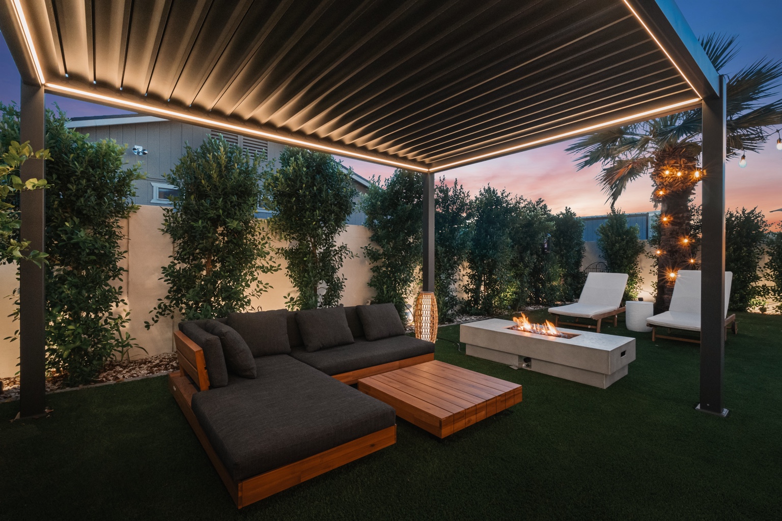 Illuminated outdoor pavilion with custom sectional at dusk
