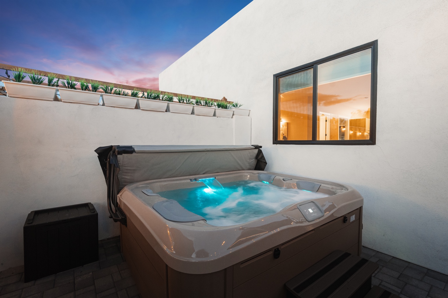 Private illuminated spa beneath an evening sky